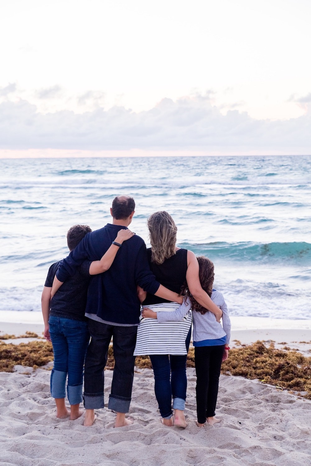 family hugging at the beach
